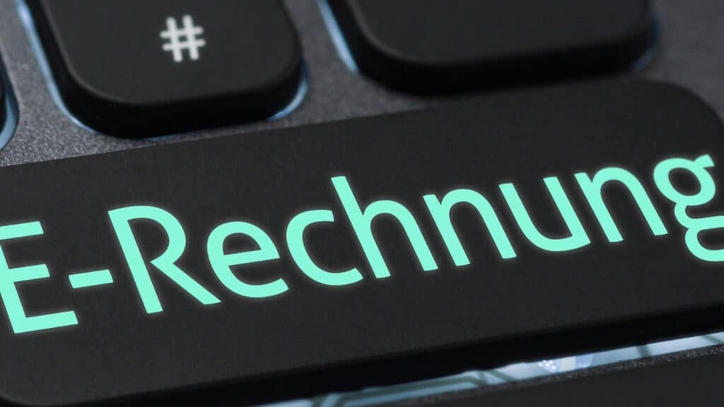 E-Rechnung auf schwarzer Oberfläche mit türkisfarbenem Schriftzug und Hashtag-Symbol, passend zu AHW und dem Thema E-Rechnungen – Quo Vadis?